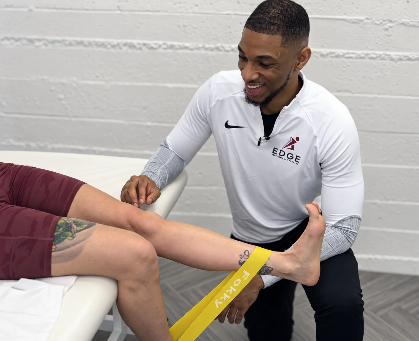 Physiotherapist Rusarn Peters assessing a client's lower leg during rehabilitation